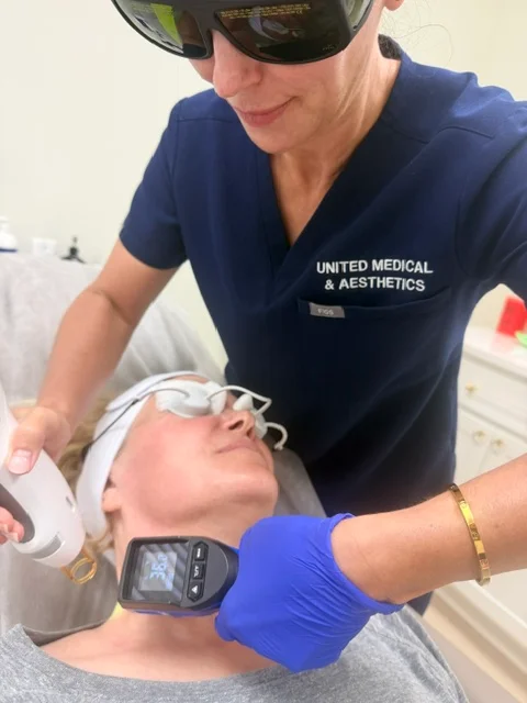 United Medical & Aesthetics staff member performing a laser facial treatment on a patient